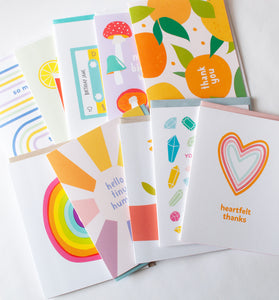 Ten colorful greeting cards spread out on a white background. 